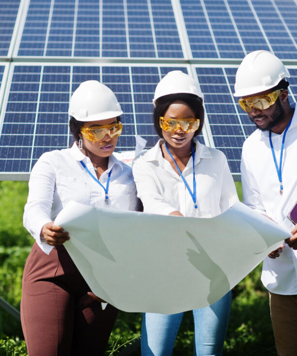 African american technician checks the maintenance of the solar panels. Group of three black engineers meeting at solar station.